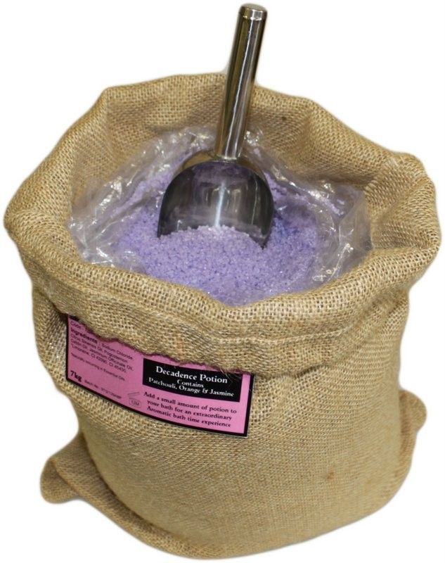 A large, rustic brown hessian sack overflowing with aromatic purple bath salts and dried lavender pieces.