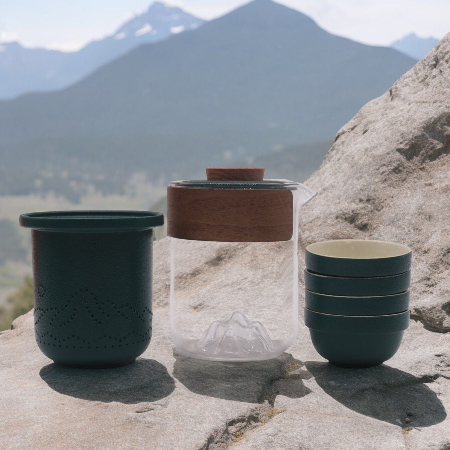 A compact, portable travel tea kit featuring a grey ceramic teapot and four stacking cups in a protective charcoal carrying case.