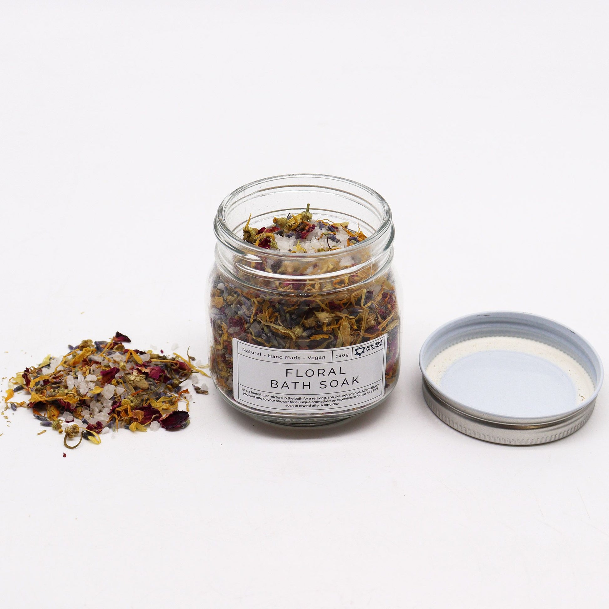 A clear glass jar filled with a premium blend of white bath salts and vibrant, multi-colored dried flower petals.