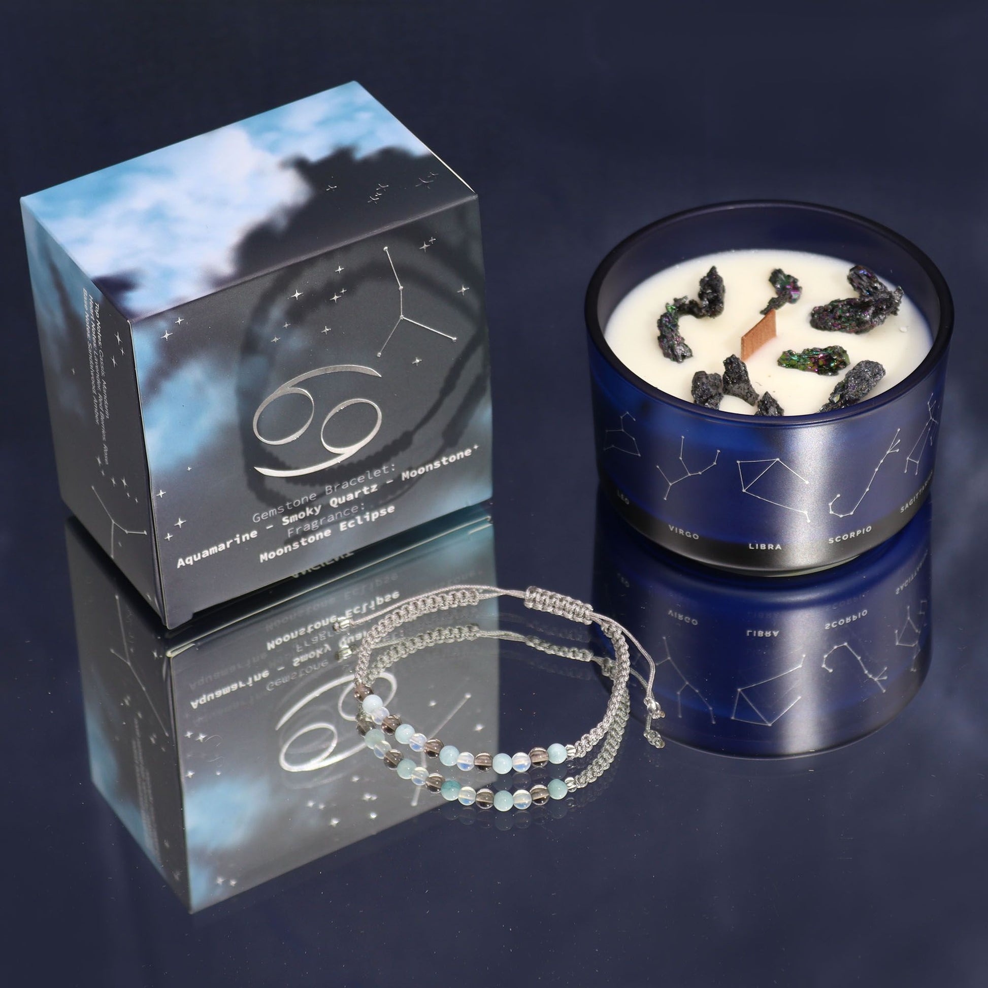 A luxury Cancer-themed candle in dark, elegant packaging with a surprise semi-precious stone bracelet reveal.