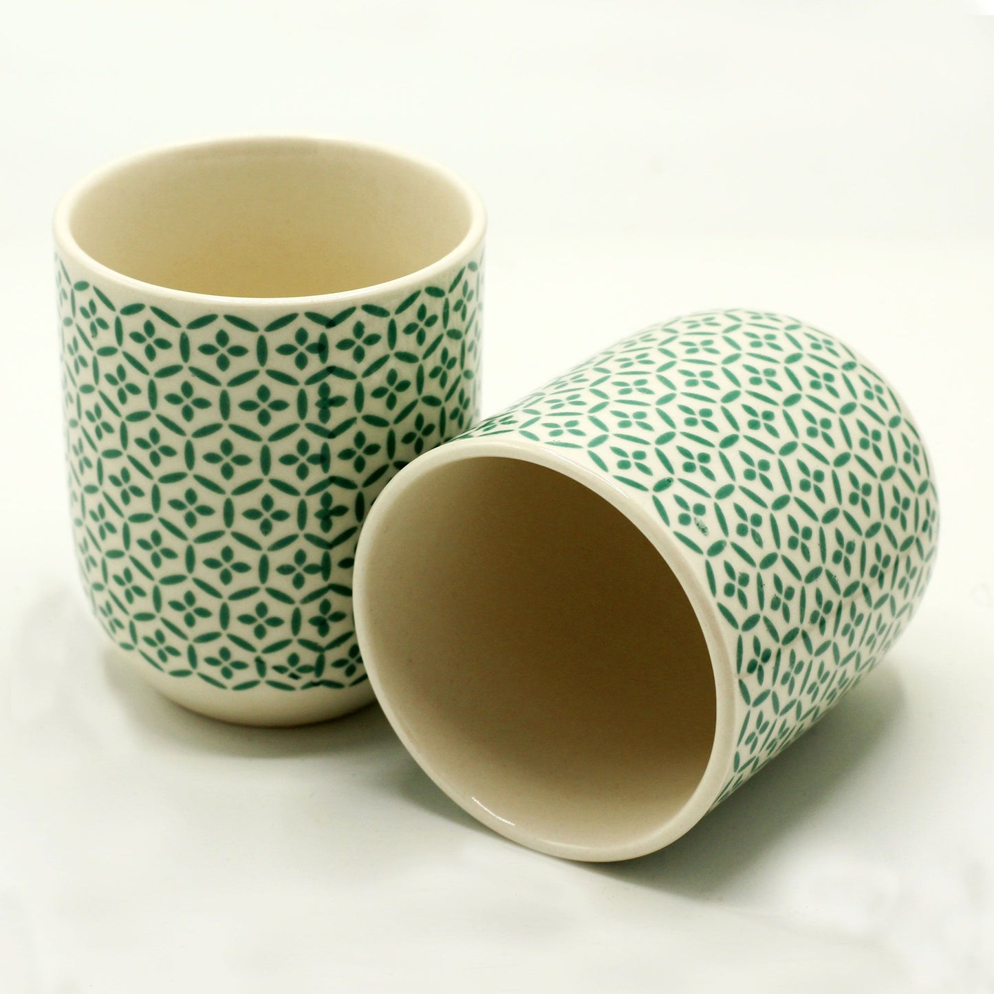 Two handleless ceramic tea cups featuring a textured, pale green mosaic scale pattern to match the mosaic teapot collection.