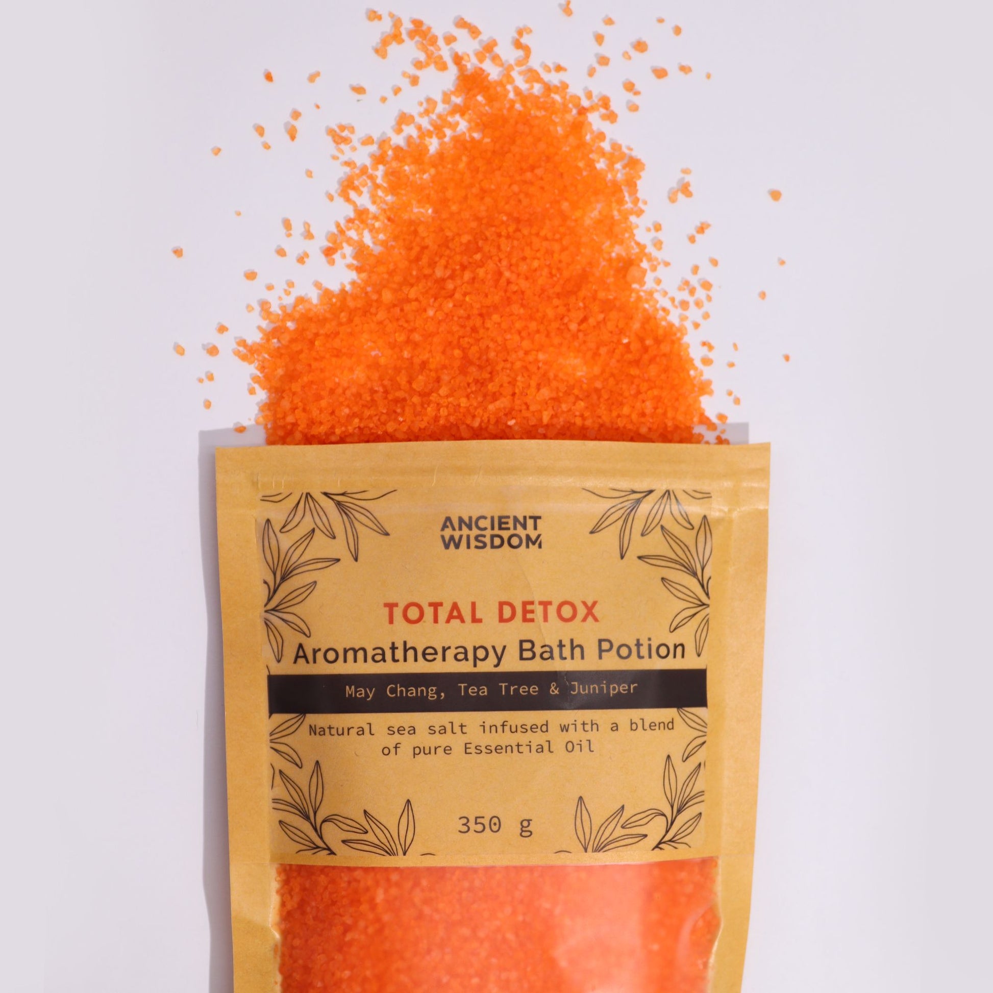 A kraft paper pouch overflowing with bright orange aromatherapy bath salts infused with purifying essential oils.