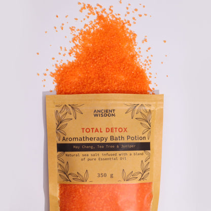 A kraft paper pouch overflowing with bright orange aromatherapy bath salts infused with purifying essential oils.