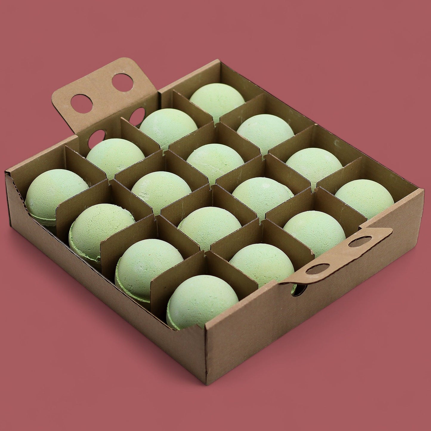 A cardboard display box holding 16 individually wrapped 180g green and white marbled bath bombs in a refreshing citrus scent.