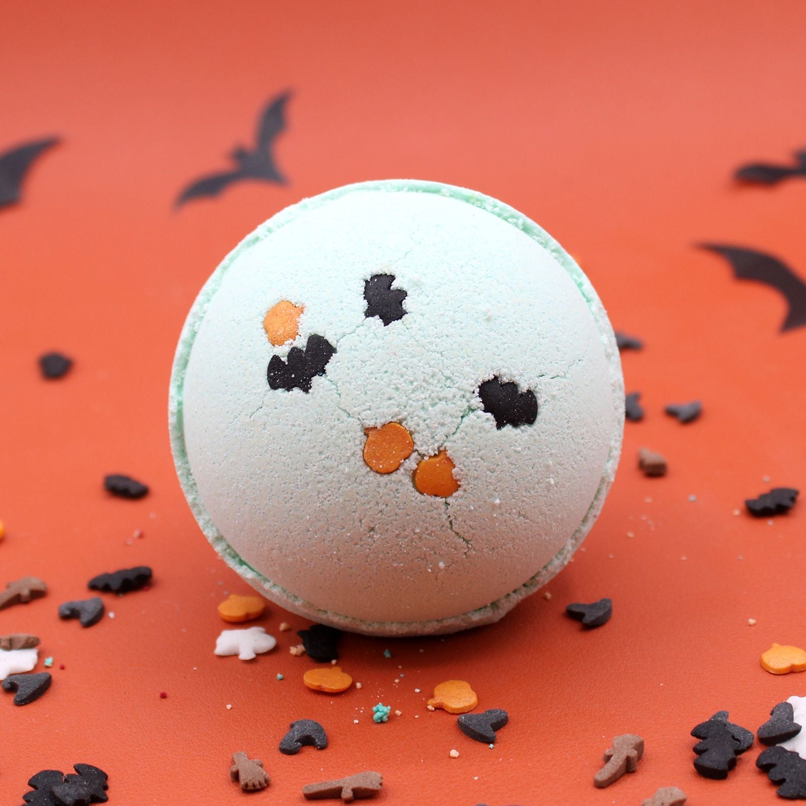 A whimsical white bath bomb shaped like a ghost with a detailed black face, perfect for a festive Halloween soak.