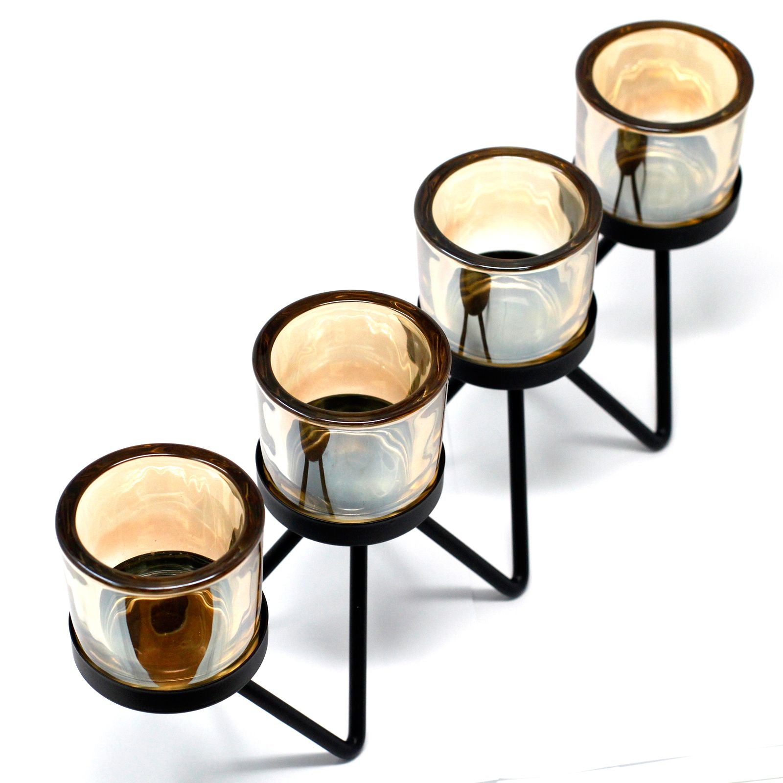 A modern black iron candle holder featuring a zigzagging metal frame that supports four separate clear glass votive cups.