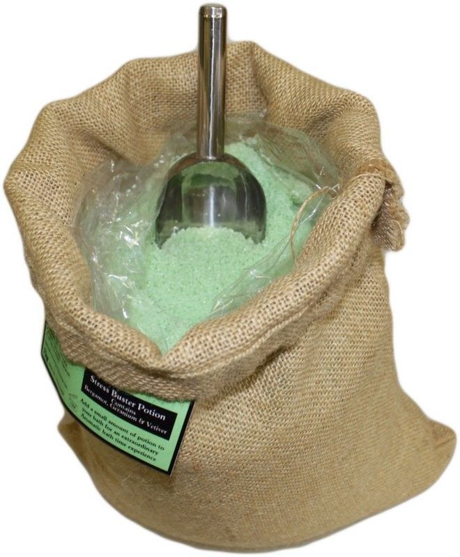 A 7kg rustic hessian sack of Stress Buster Potion bath salts with a green label and a traditional wooden scoop for bulk use.