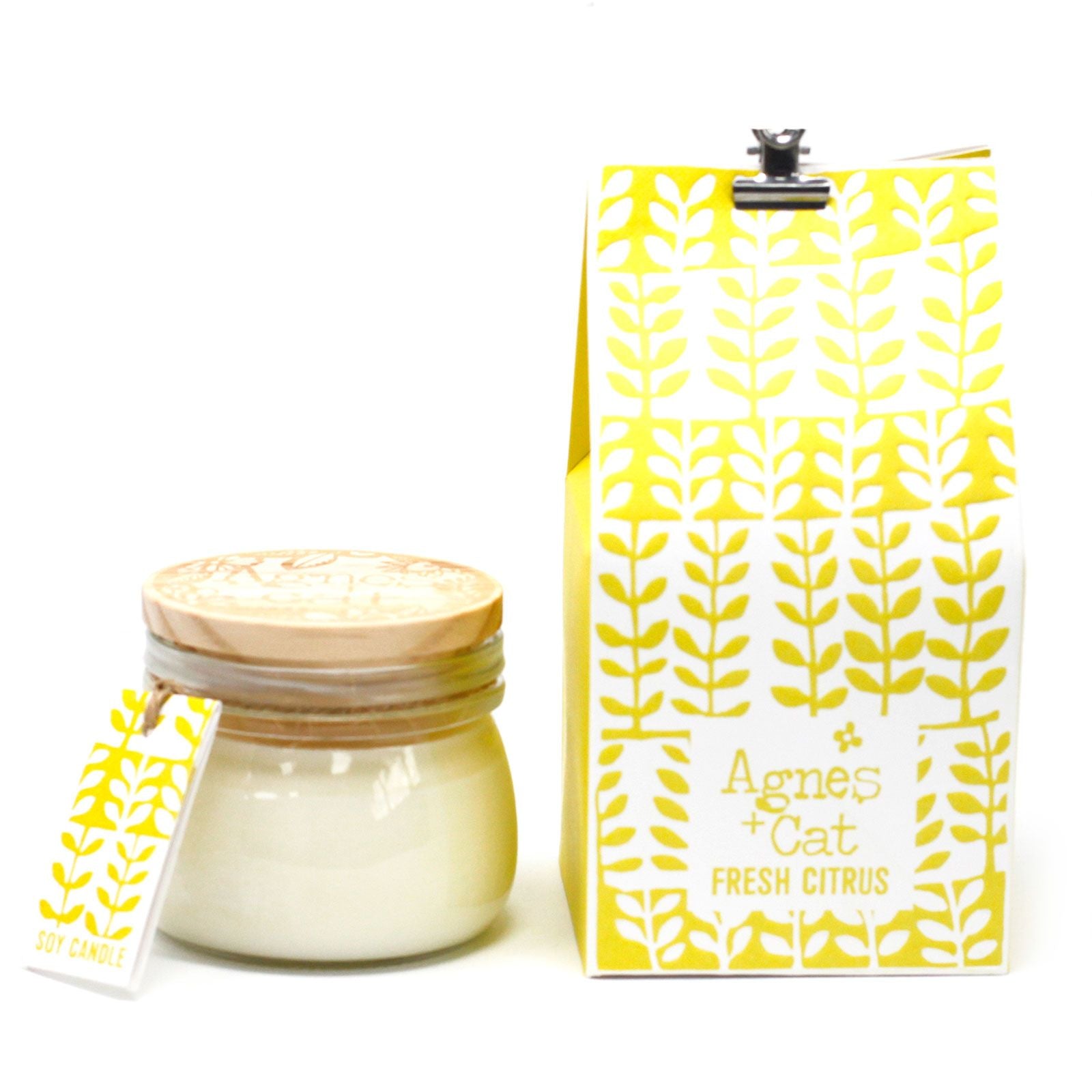 A clear glass Kilner jar with a yellow and gold citrus-themed label, containing a zesty hand-poured candle.