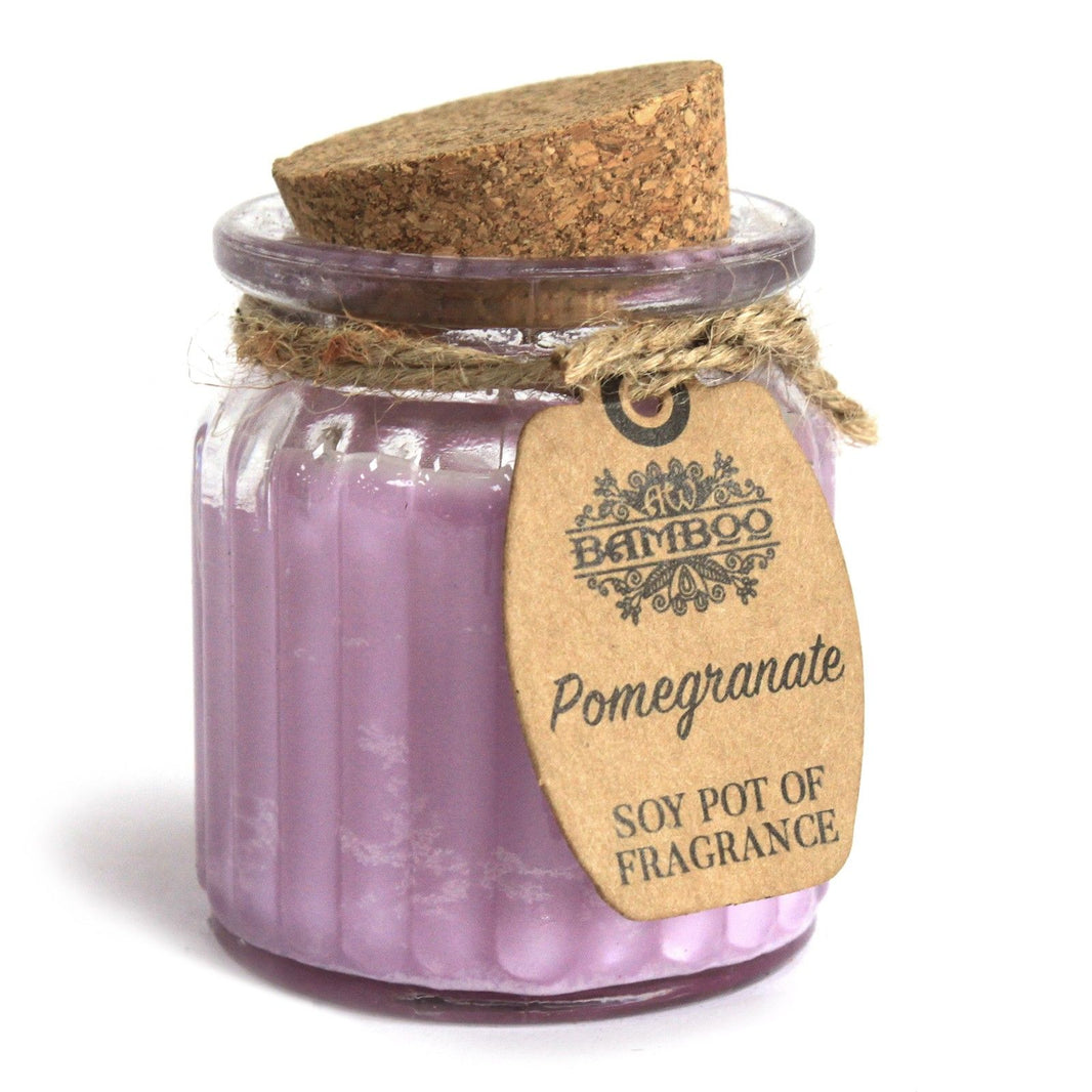 A small purple-toned soy wax candle in a glass pot with a natural cork lid, scented with fresh pomegranate.