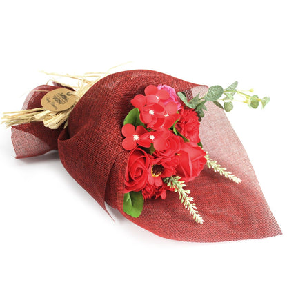 A standing bouquet of vibrant red soap flowers wrapped in decorative paper and tied with a red ribbon.