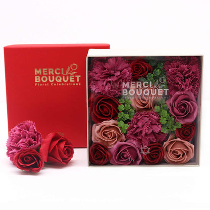 A red square box containing a beautiful arrangement of pink and mauve soap roses in a vintage aesthetic.