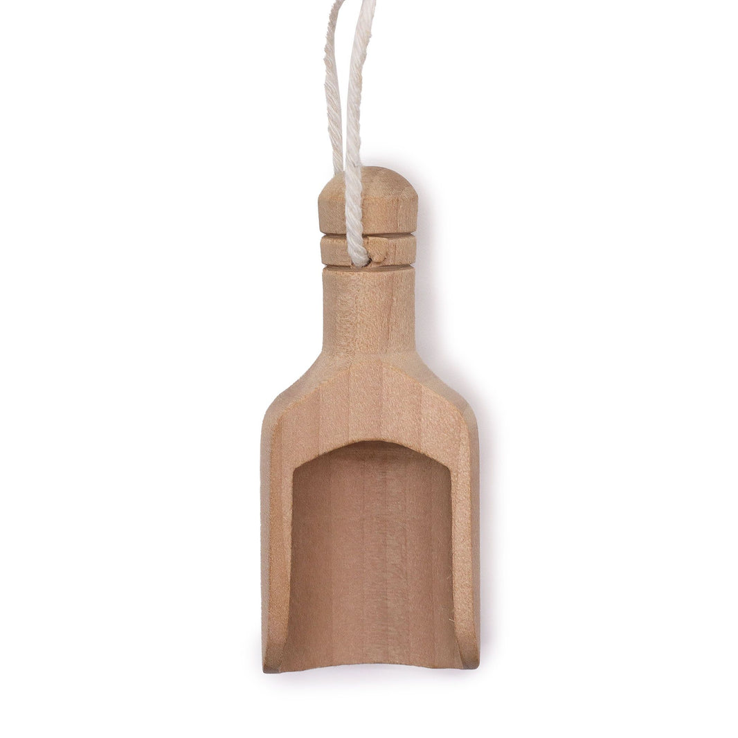 A small, handcrafted natural wooden scoop, perfect for measuring bath salts, tea, or apothecary powders.
