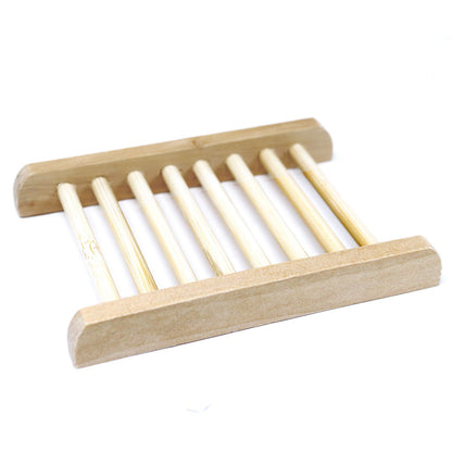A light-colored natural Hemu wood soap dish in a ladder-style design with thin slats for efficient drainage.