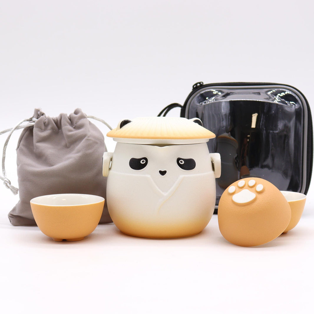 A vibrant orange and white ceramic teapot decorated with panda motifs and three coordinating small handleless cups.