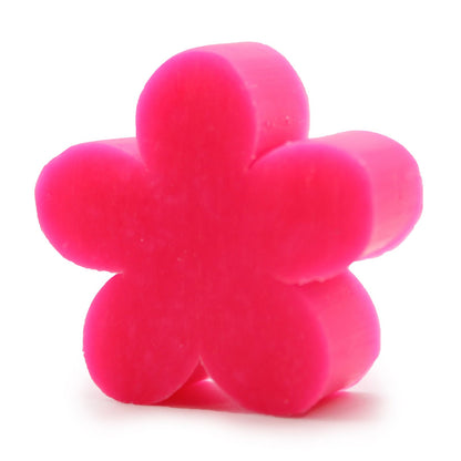 A small, bright pink artisan guest soap bar sculpted into a realistic flower shape with defined, layered petals.