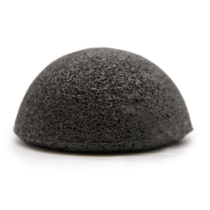 A black, round natural Konjac facial sponge infused with bamboo charcoal for skin detox and pore cleansing.