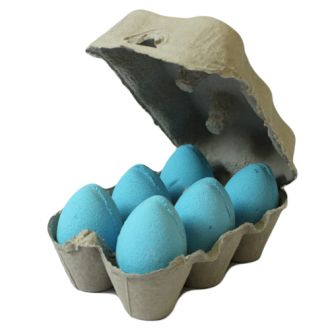 A grey egg carton containing six vibrant blue egg-shaped bath bombs with a sweet and nostalgic blueberry fragrance.