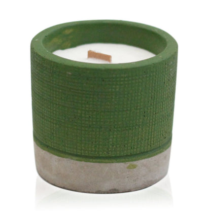 A minimalist green concrete pot filled with a white soy candle, featuring a wooden wick and an industrial aesthetic.
