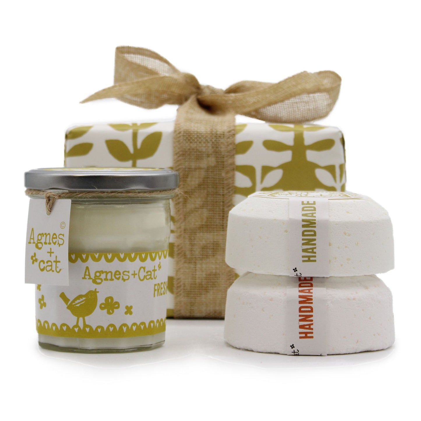 A luxury spa gift box containing a citrus-scented candle and large artisan bath fizzers, tied with a cream-colored bow.
