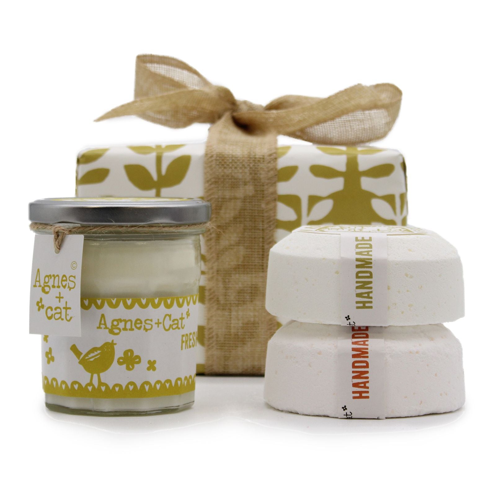 A luxury spa gift box containing a citrus-scented candle and large artisan bath fizzers, tied with a cream-colored bow.