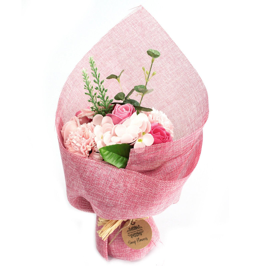 A standing arrangement of various pink soap flowers wrapped in decorative pink paper and ribbons.