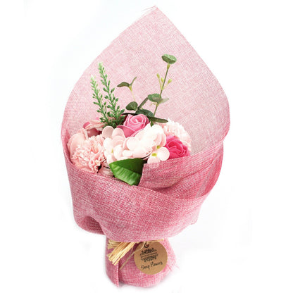 A standing arrangement of various pink soap flowers wrapped in decorative pink paper and ribbons.