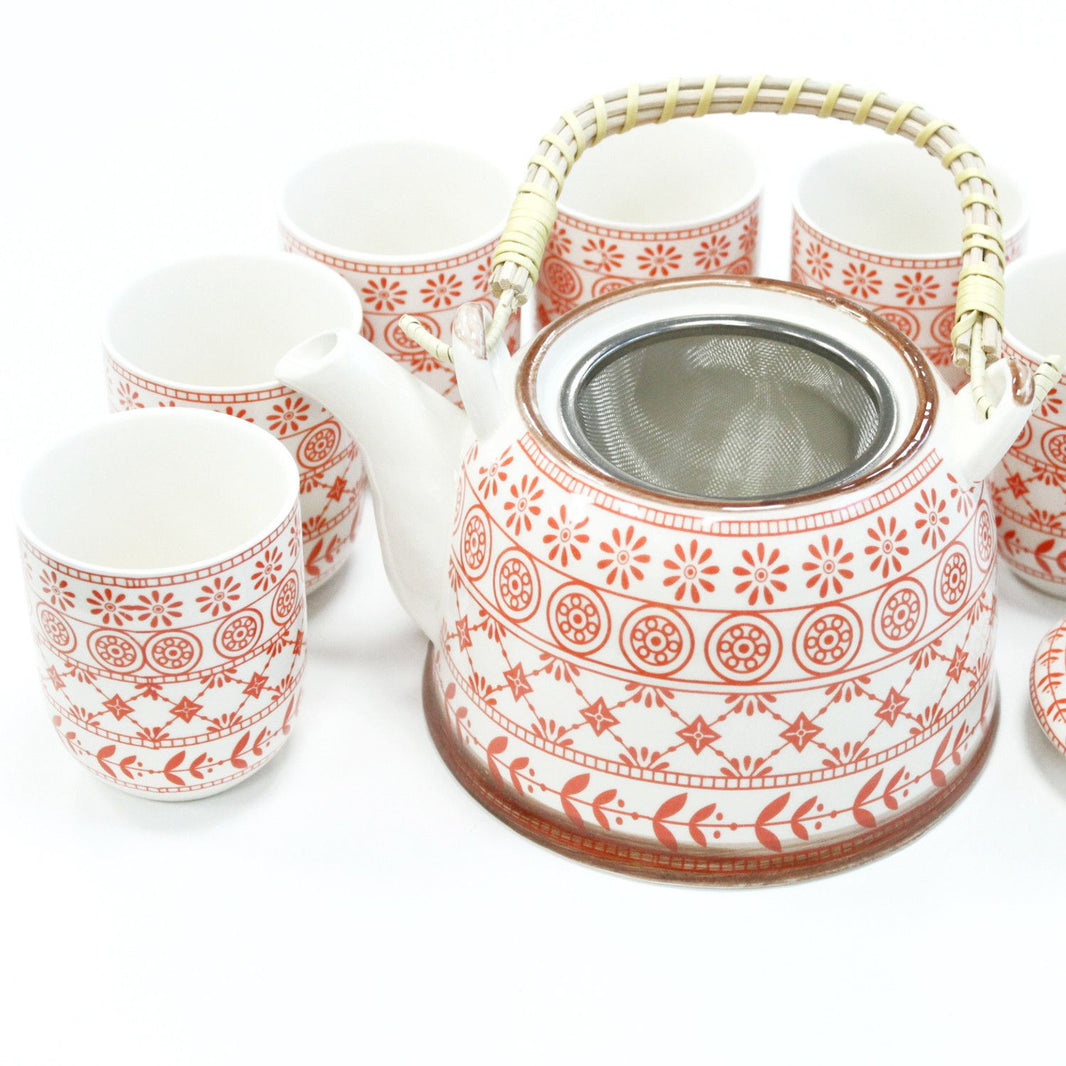 A warm amber-colored ceramic teapot with a matching warmer and cups featuring a tactile geometric relief pattern.