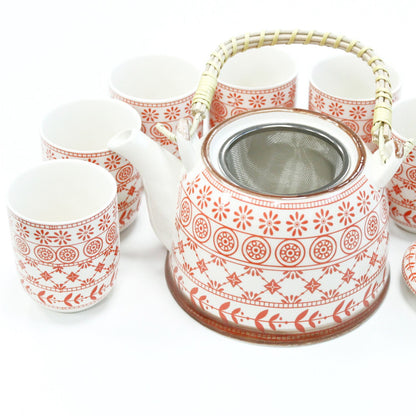 A warm amber-colored ceramic teapot with a matching warmer and cups featuring a tactile geometric relief pattern.