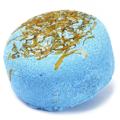 A vibrant blue spherical bath bomb topped with golden botanicals and dried flower petals for a luxury bath experience.