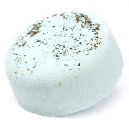 A light-colored, speckled bath bomb topped with a delicate scattering of dried botanical ingredients.