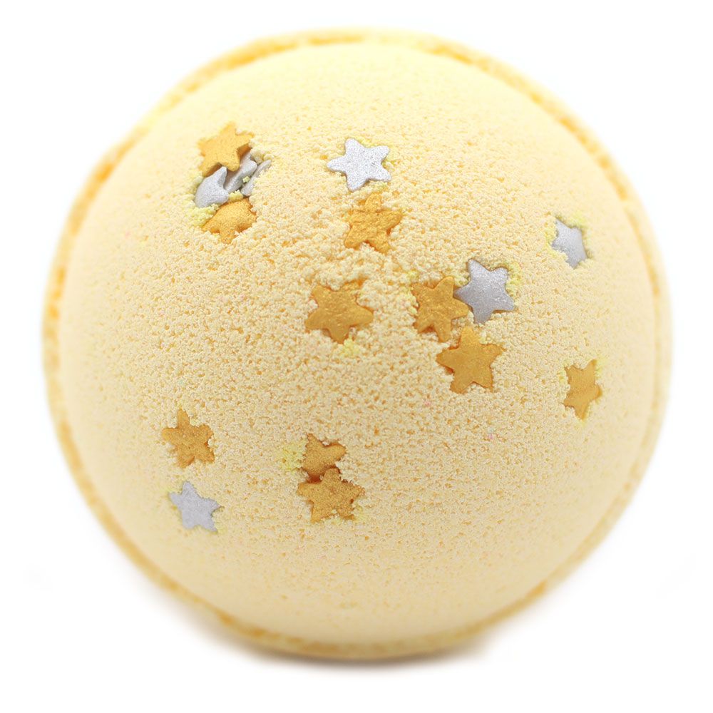 A large, star-shaped yellow bath bomb decorated with gold glitter and white star speckles for a festive bath.