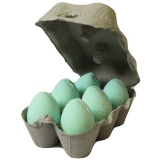 A grey egg carton holding six pale green egg-shaped bath bombs featuring a fresh and zesty mango fragrance.