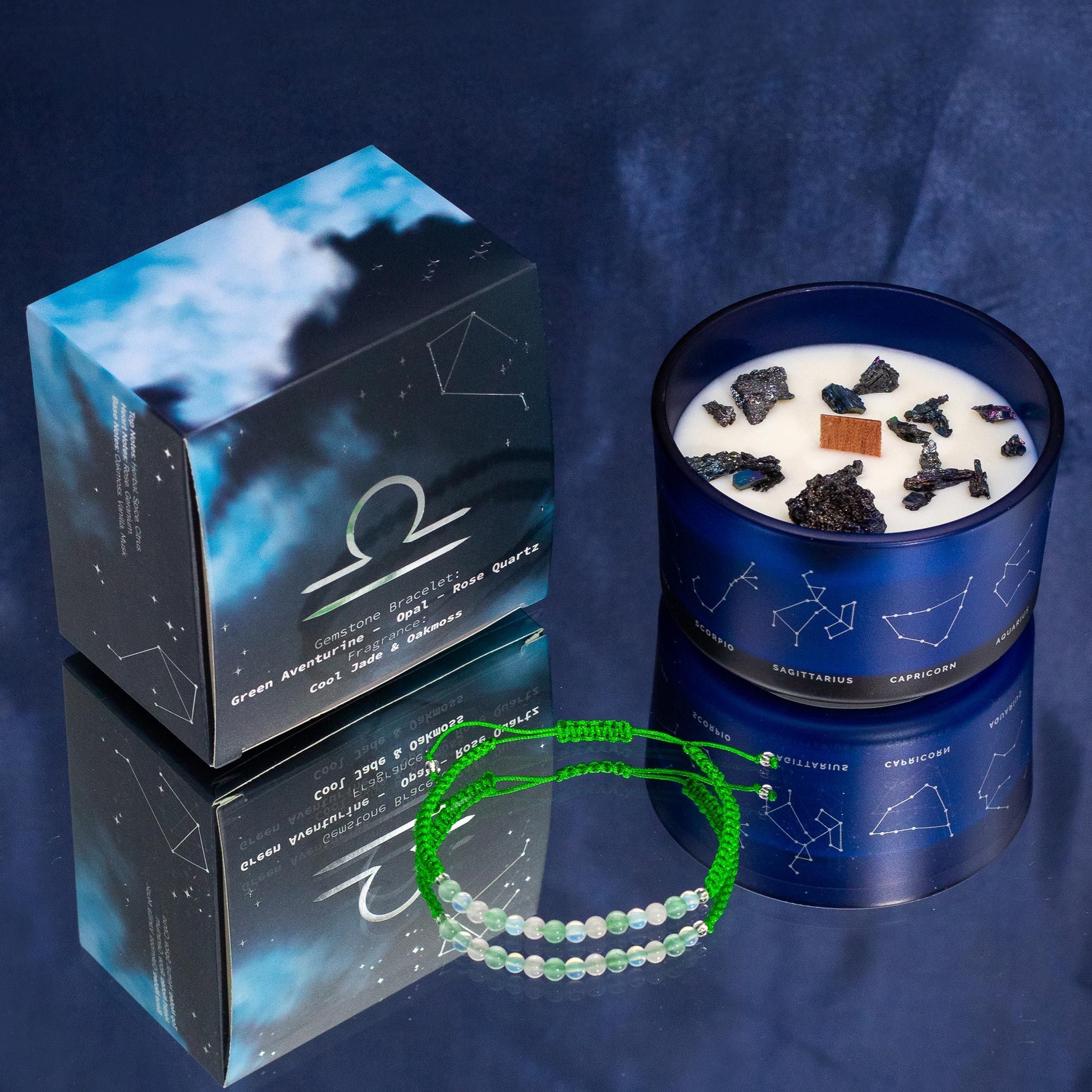 A luxury black candle tin with gold Libra constellation details and a corresponding semi-precious stone bracelet.