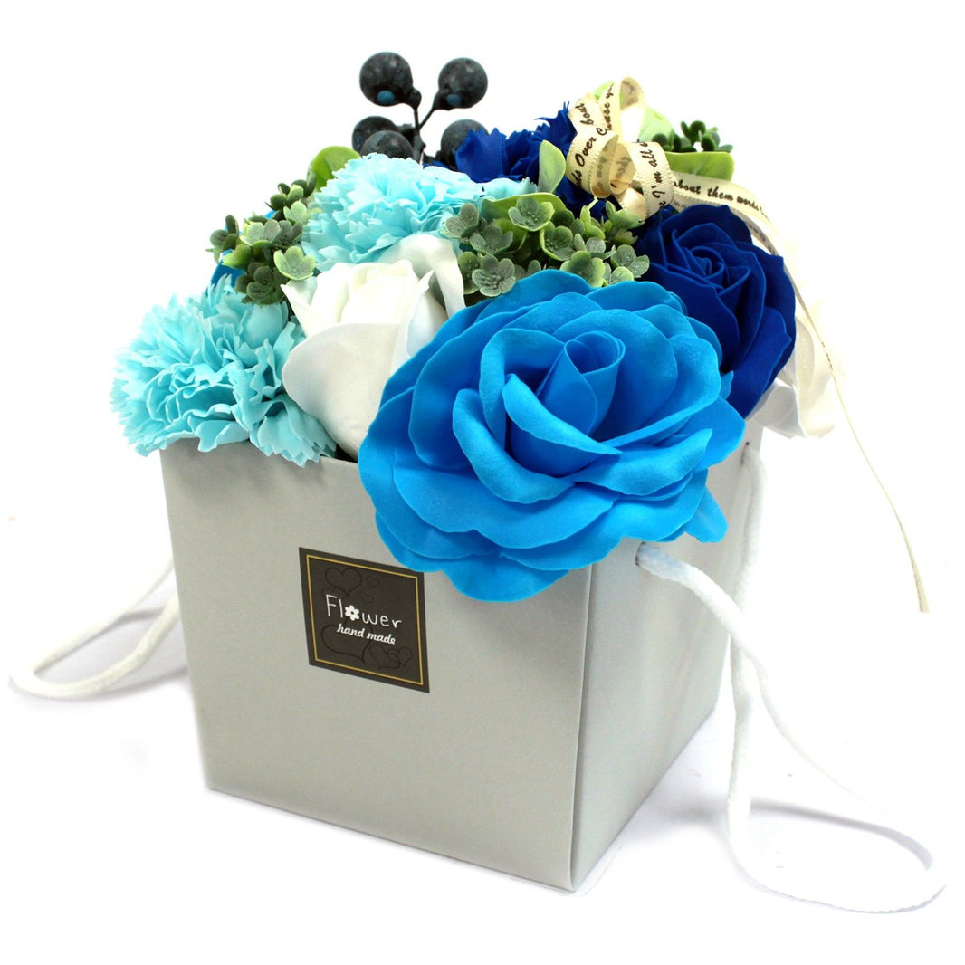 A luxury soap flower bouquet with blue and white roses and carnations in a grey gift box.