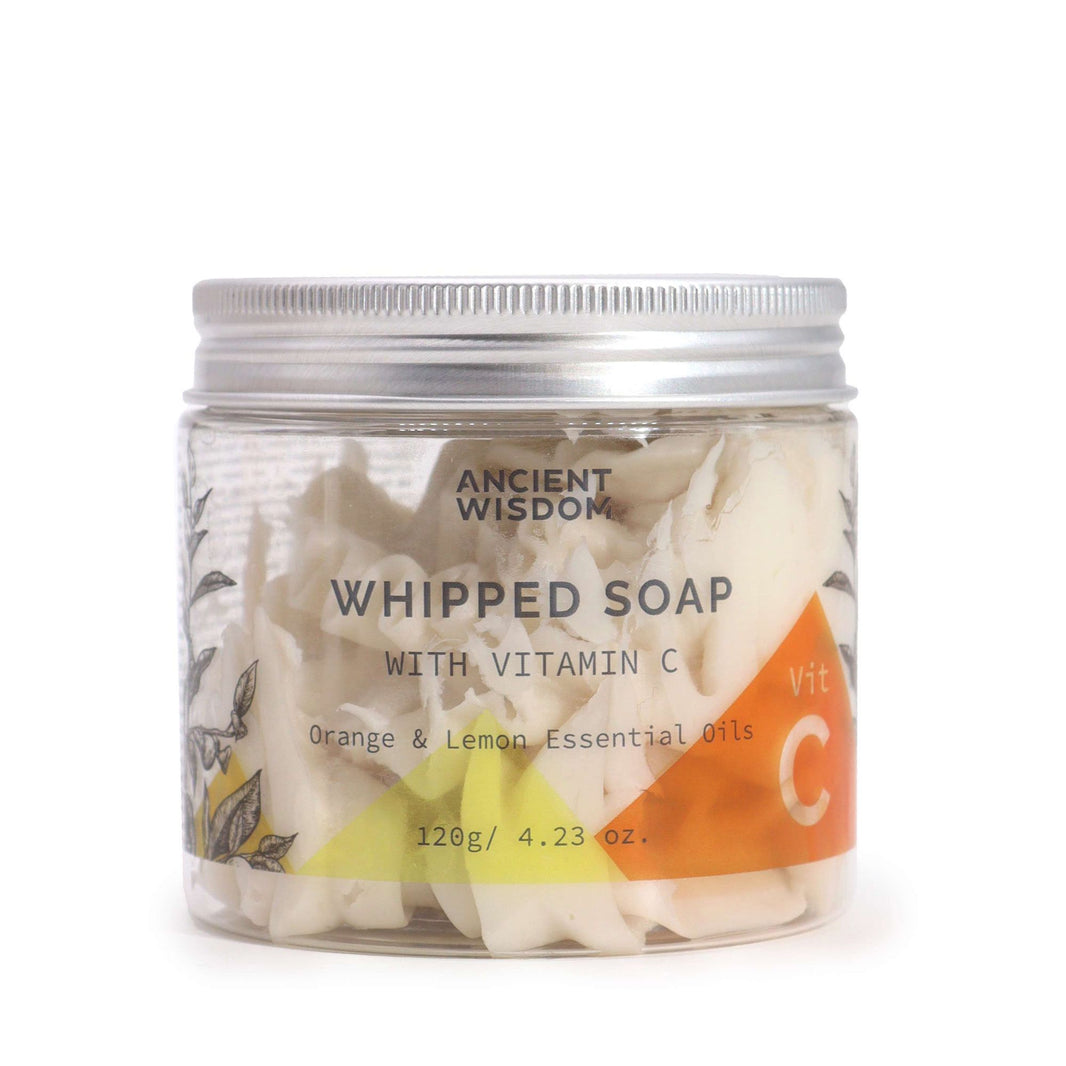 A clear jar of whipped cream soap showing a vibrant yellow and white swirled texture, perfect for a luxury shower experience.