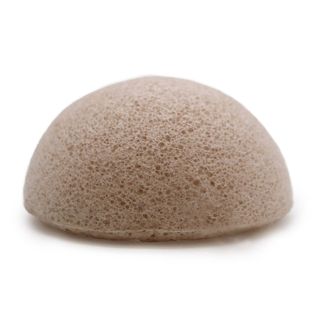 A round, cream-colored natural plant-based Konjac sponge for chemical-free facial exfoliation.